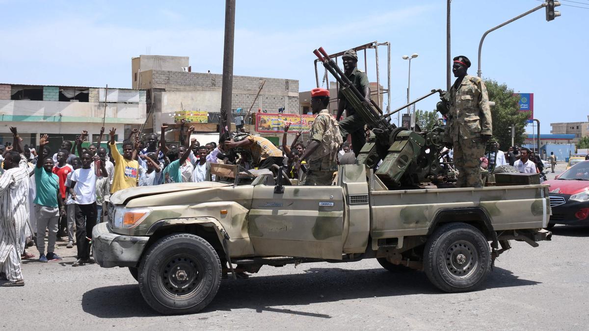 Los sudaneses saludan a los soldados del ejército, leales al jefe del ejército Abdefatá al Burhan, en la ciudad Puerto Sudán, este domingo.