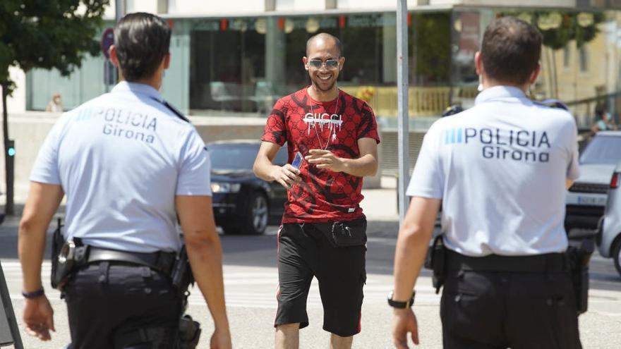 Agents de la policia municipal s&#039;adrecen a una persona sense mascareta.