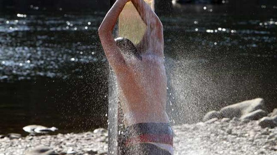 Un joven se refresca en Ourense. // I. Osorio