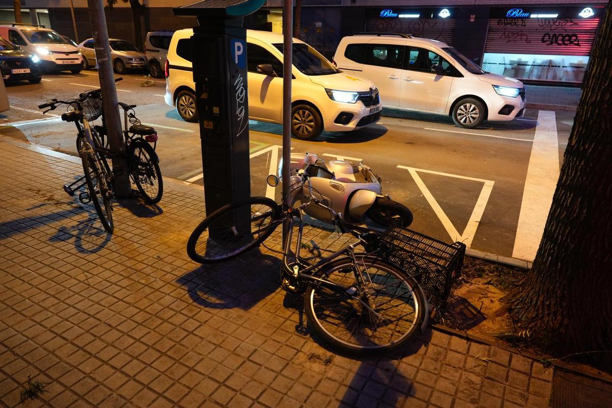 Bicicletas y motos en el suelo, por las fuertes rachas de viento, en la calle de Bac de Roda a la altura de Marroc.
