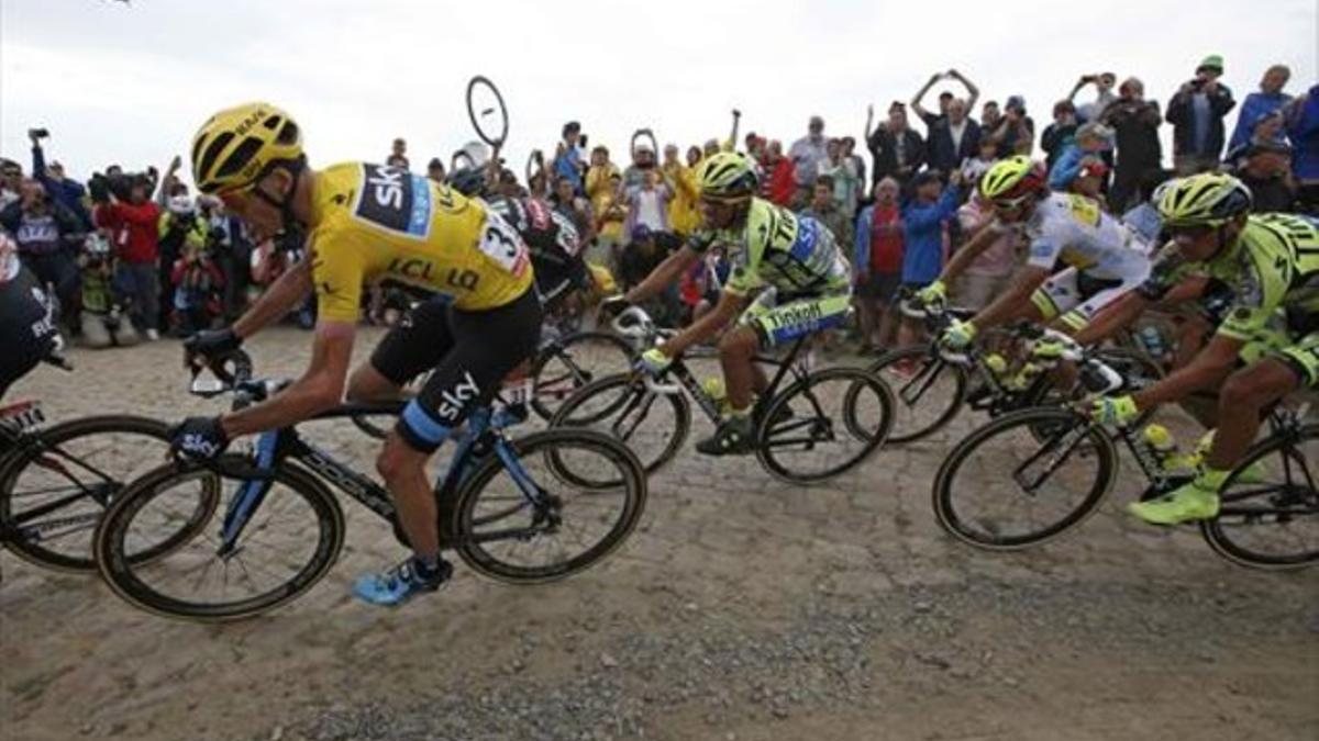 Contador (en el centro) sigue a Froome (de amarillo) en uno de los tramos del temido pavés, en la etapa de ayer en el Tour.