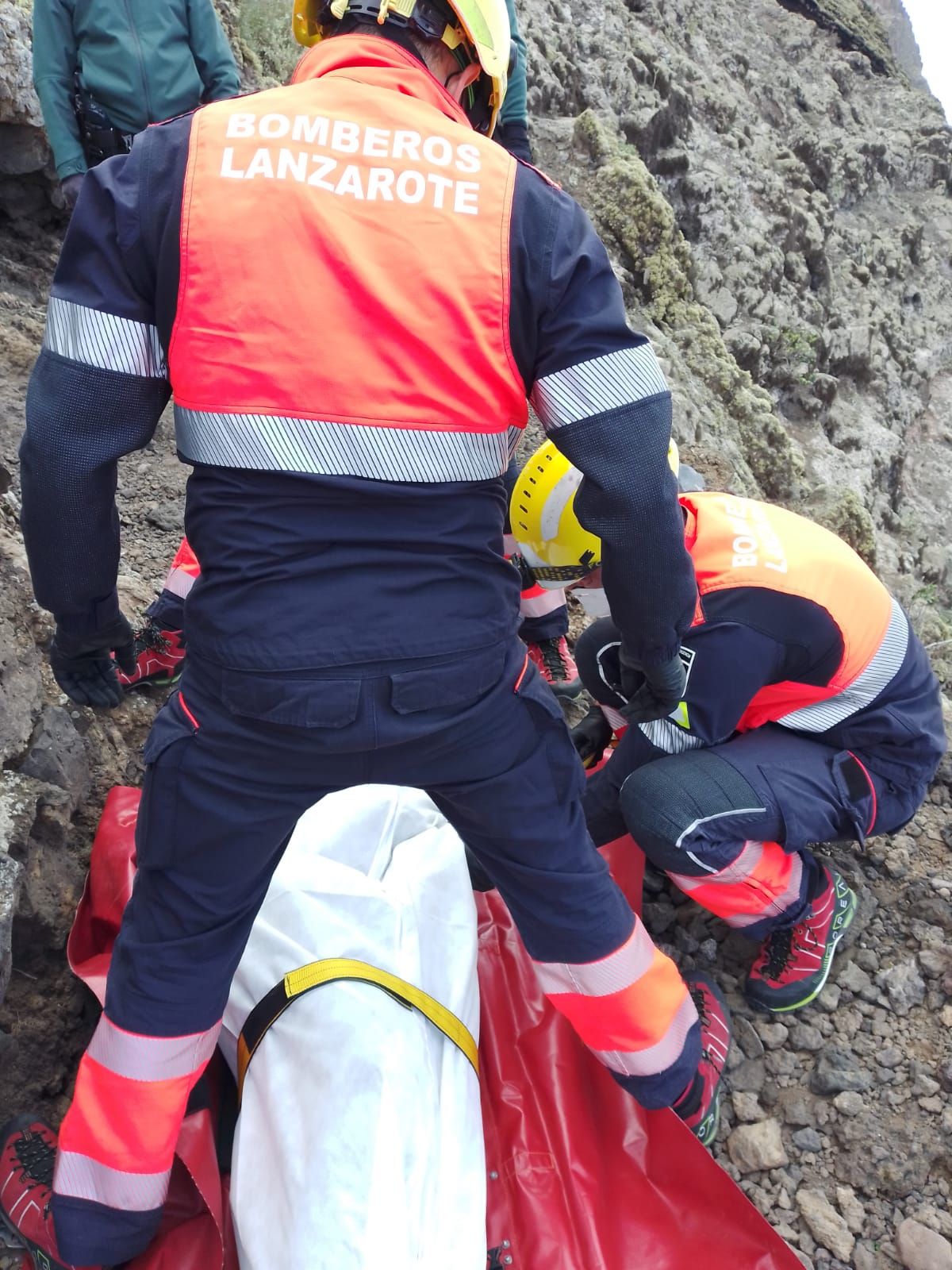 Los bomberos con el cuerpo del fallecido en el camino de Las Rositas.