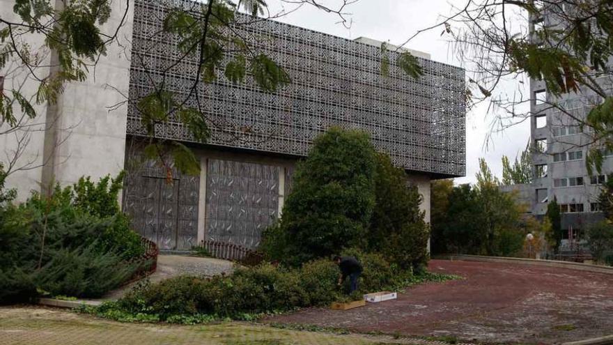 Un operario retira maleza en el edificio del Banco de España, futura sede de la Policía Municipal.