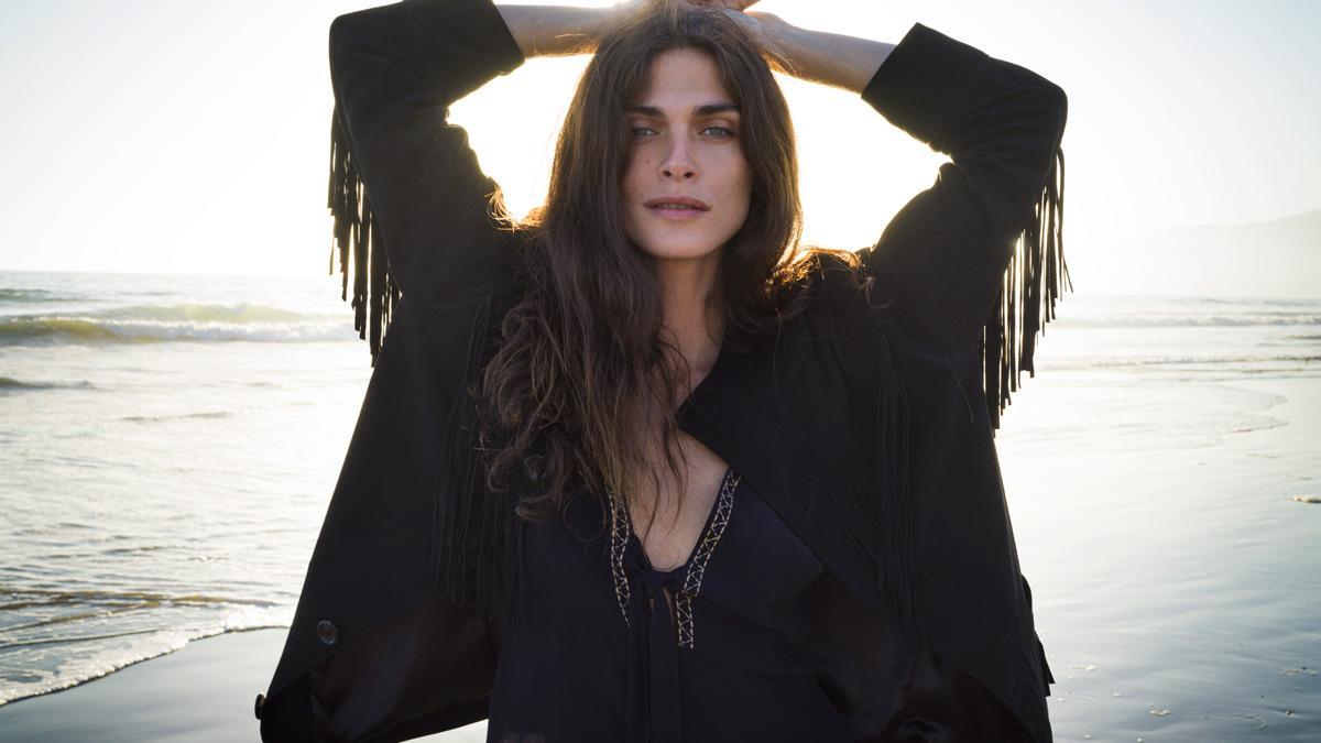 Elisa Sednaoui posa con la chaqueta negra de piel de ante con flecos, de la colección Antik Batik x Funtasia