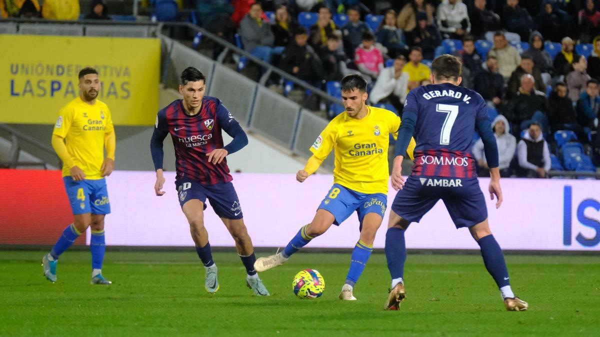 Fabio controla el esférico en presencia de dos rivales del Huesca