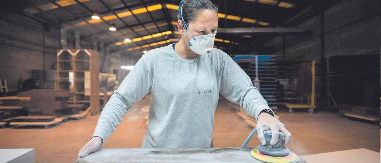 Una empleada de la empresa valenciana del sector del mueble Loyra trabaja en el pulido de una de las piezas.