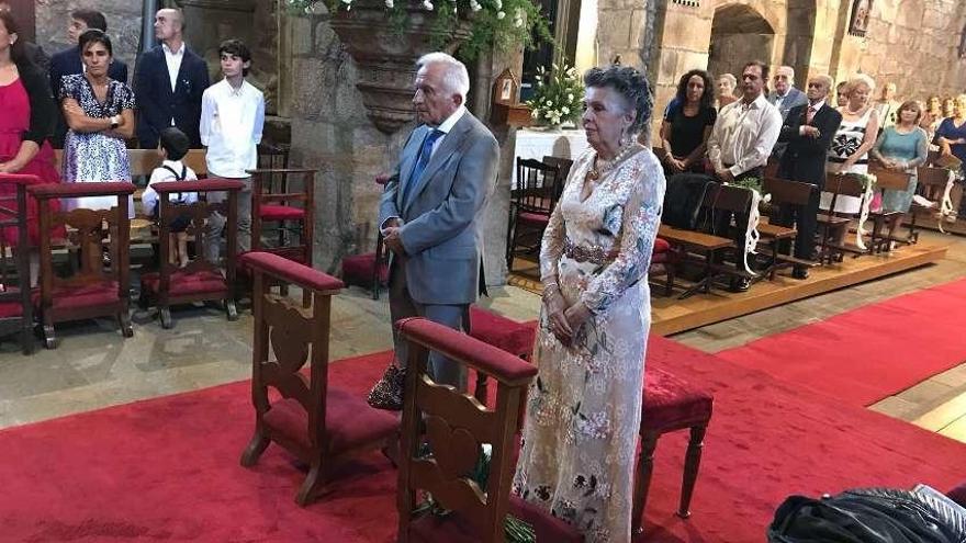 El matrimonio, acompañado por familiares y amigos, ayer, en la misa en la iglesia de Fefiñáns. // Bernabé