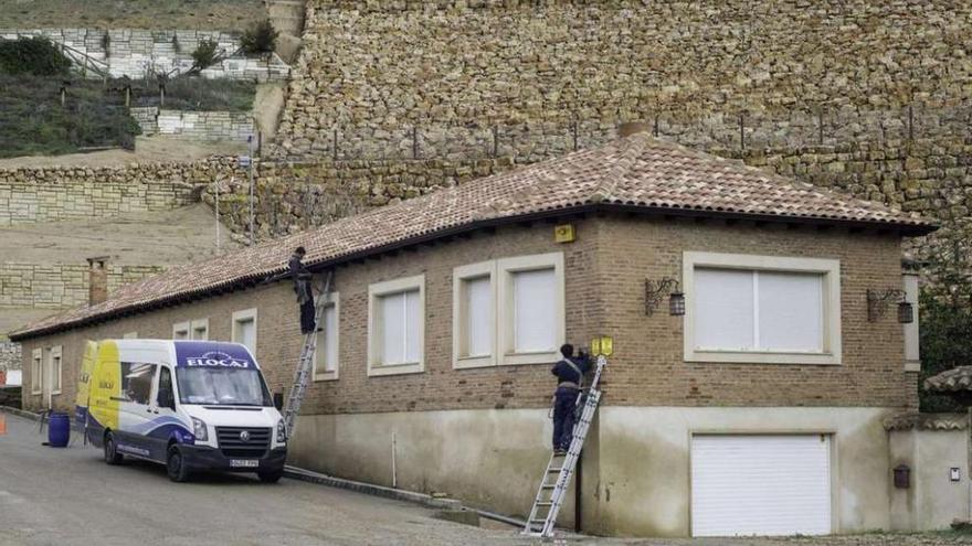 Dos electricistas trabajan en la vivienda tras levantarse el precinto.