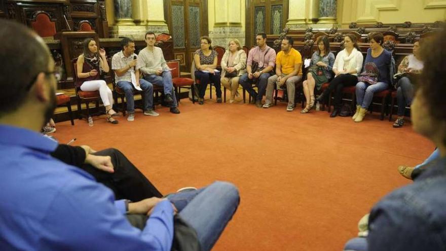 Miembros de ANPA de centros de Primaria en el Concello escuchan al alcalde, con el micrófono.