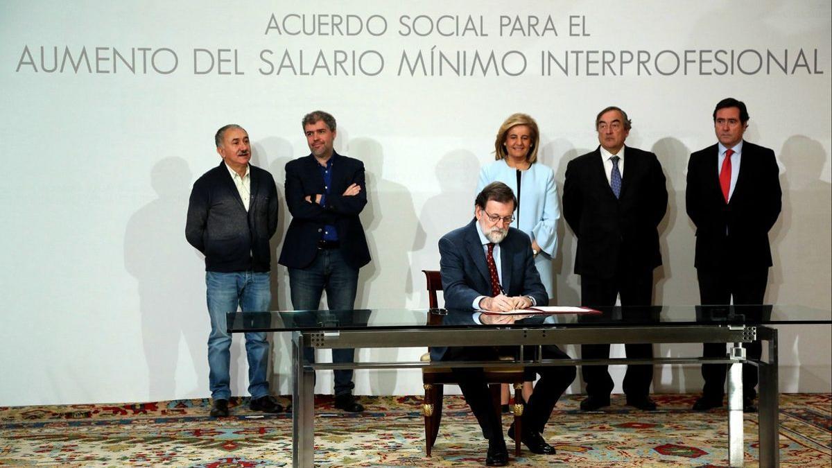Rajoy firma el acuerdo para elevar el salario mínimo, en presencia de los representantes de las patronales y los sindicatos mayoritarios.