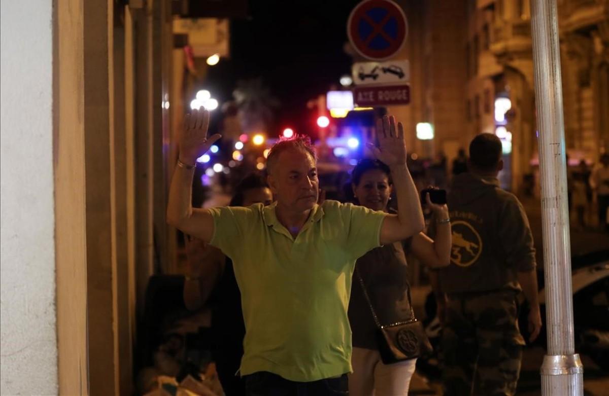 Un hombre camina con las manos en alto debido a los controles policiales.