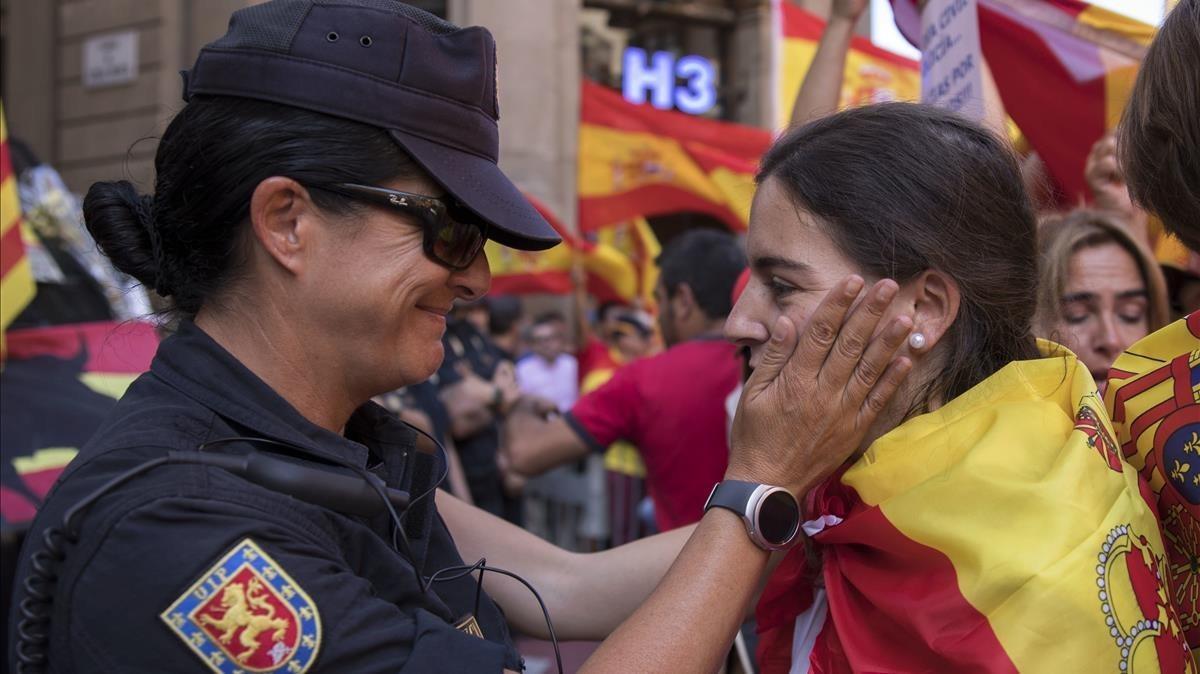 Un oficial de policía español habla con un manifestante