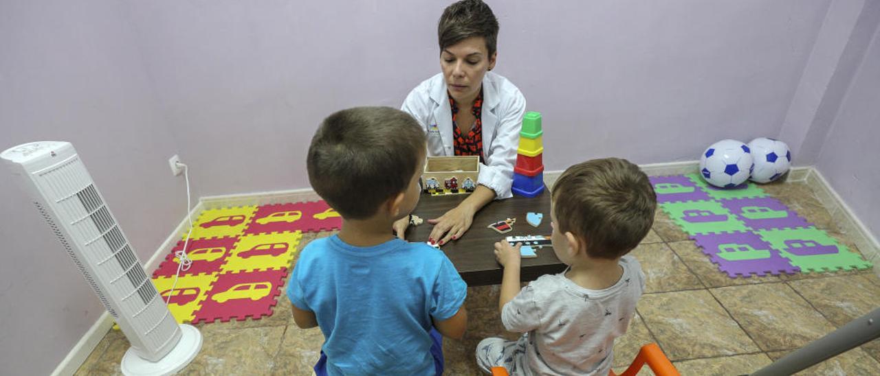 Dos niños recibiendo terapia en el local cedido por una de las madres de la asociación.