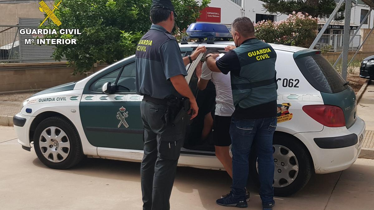 El detenido es introducido en el coche policial