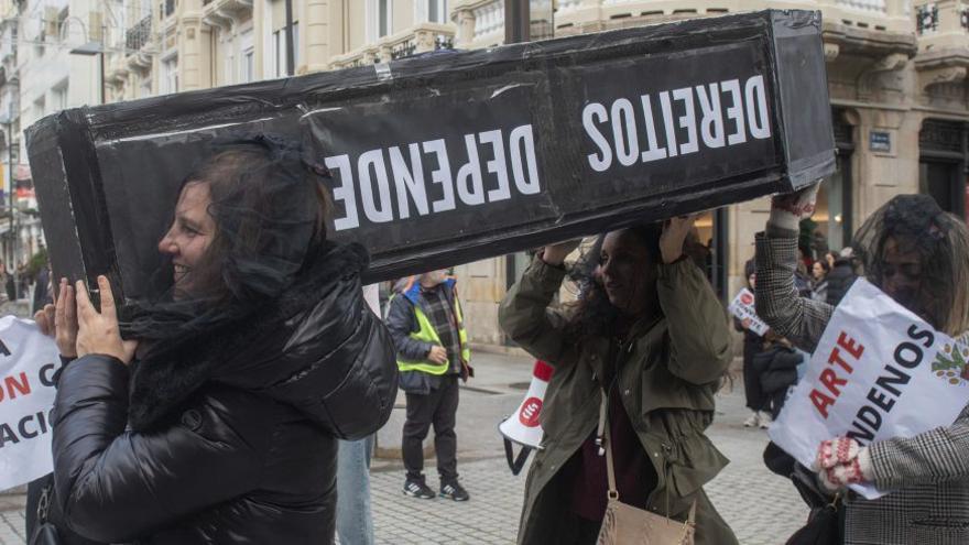 Varias manifestantes portan un ataúd en el que se puede leer ‘Dereitos Dependentas’. |  Casteleiro