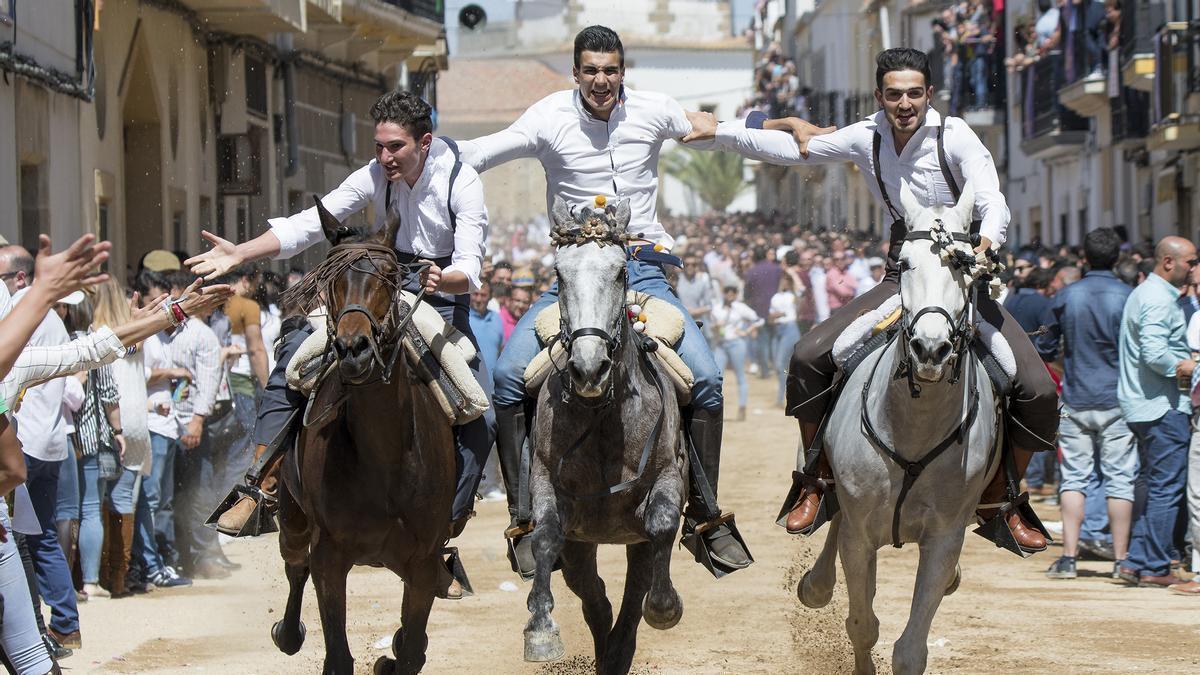 Tres jinetes bajando en collera, por la Corredera en una vertiginosa carrera.