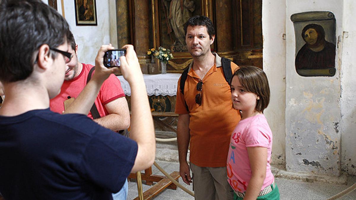 Dos visitantes se fotografían junto al eccehomo de Borja.