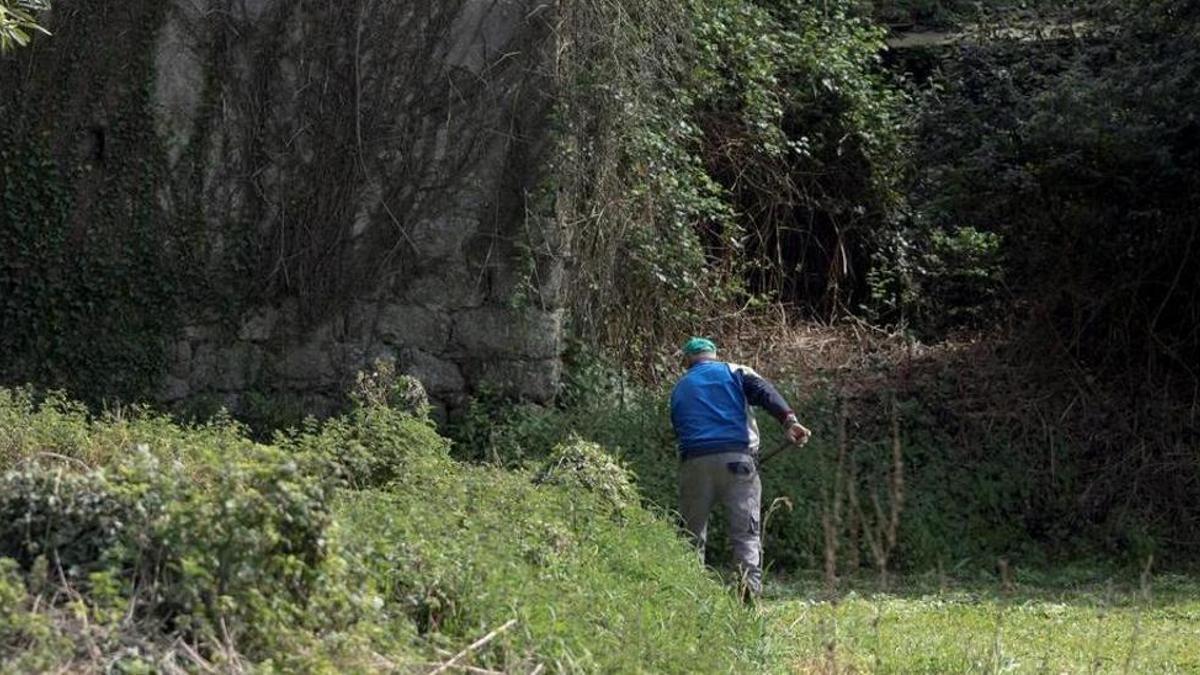 Un hombre trabaja en una finca de una aldea de Lugo en semiabandono.