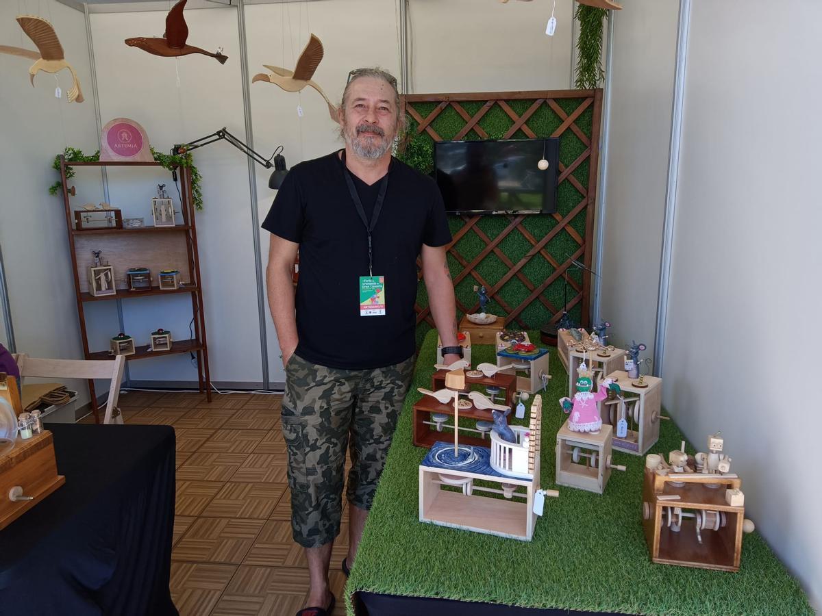El artesanoa de madera Roberto Gavazzi junto a sus piezas de juguete para decoración.