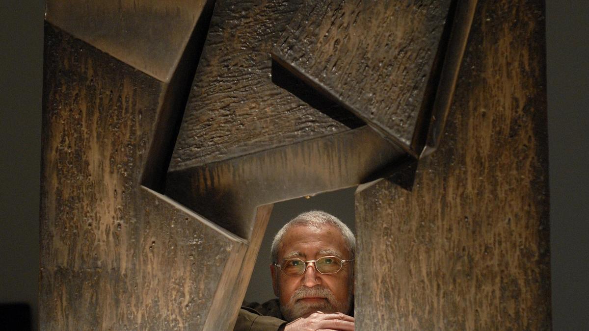 El escultor Enric Mestre se asoma tras una de sus obras cerámicas.