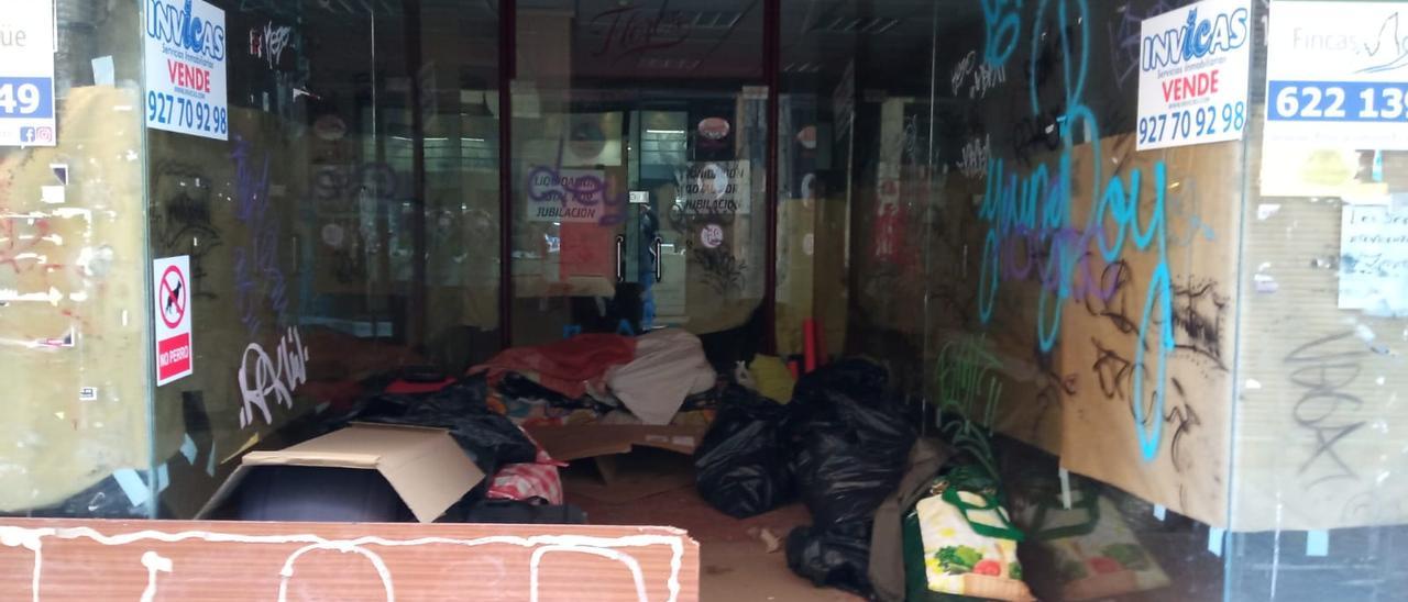Local lleno de grafiti, cartones y bolsas, en la calle Pedro Isidro de Plasencia.