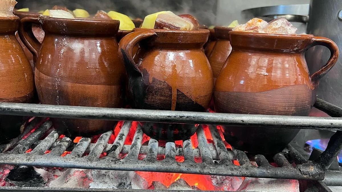 En Taberna la Bola preparan el cocido madrileño en unas vasijas de barro sobre brasas