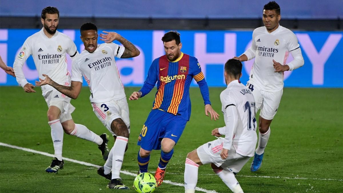 Leo Messi envuelto de jugadores del Real Madrid durante el clásico