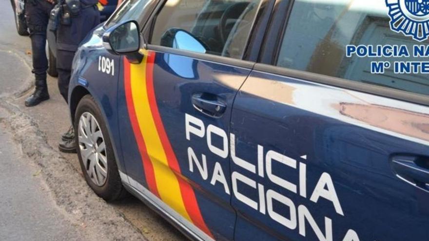 Agentes de la Policía Nacional, junto al coche patrulla.