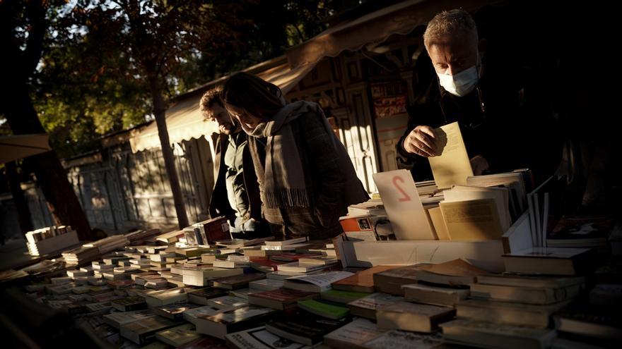 Clientes en uno de los expositores de las librerías de la cuesta de Moyano, en Madrid.