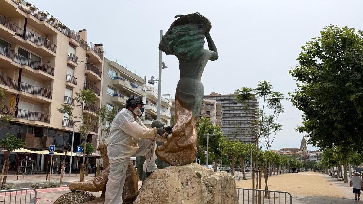Tècnics treballant en la restauració de l'escultura.