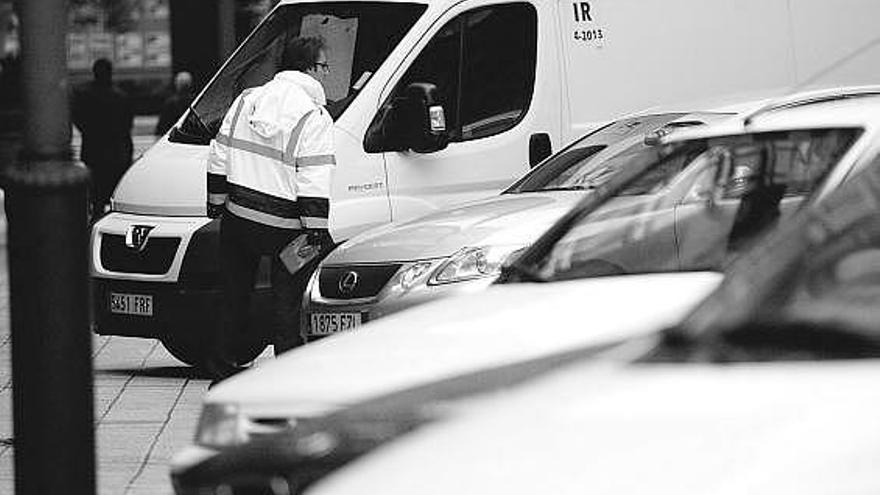 Un controlador de la ORA de Avilés vigila los coches aparcados en la zona regulada.