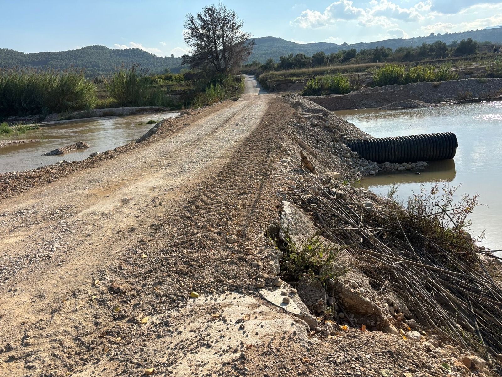 Pasarela provisional realizada con grava tras la dana sobre el Magre en Turís para unir zonas agrícolas.