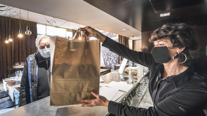 Un client s’emporta una bossa de menjar preparat del restaurant del teatre Kursaal de Manresa | OSCAR BAYONA
