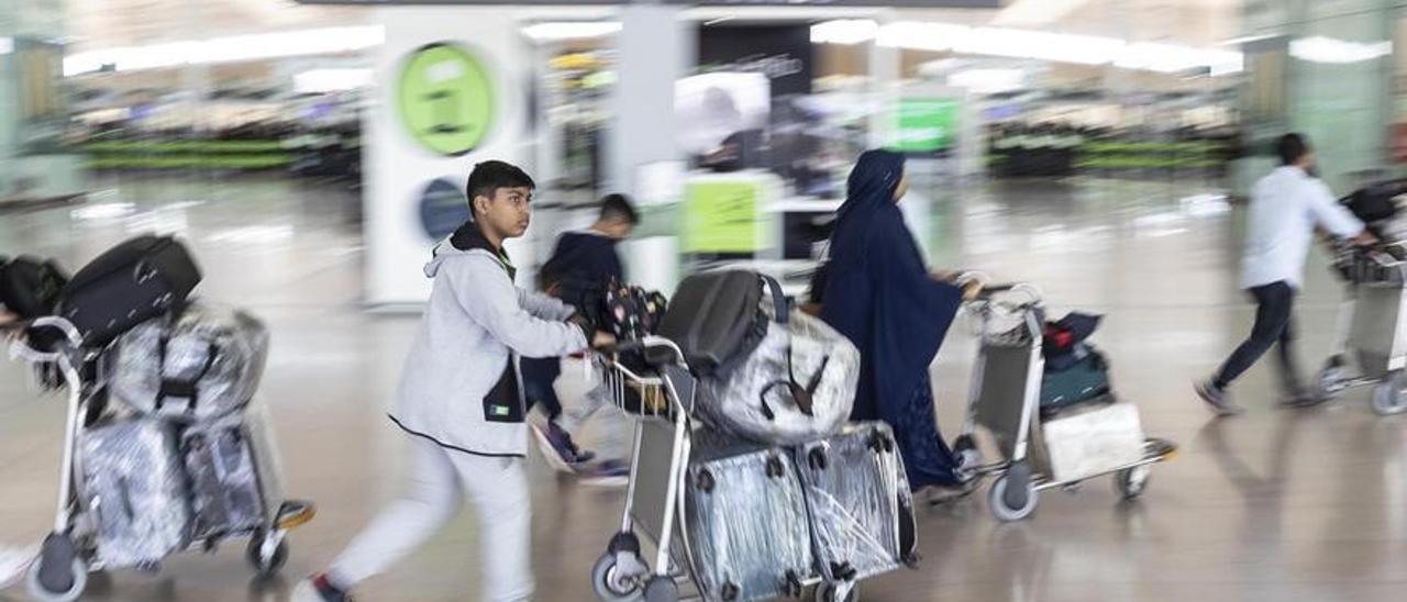 Pasajeros con maletas en la T1 del aeropuerto de El Prat.