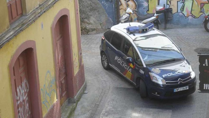 Un coche de la Policía Nacional, circula por una calle del centro.