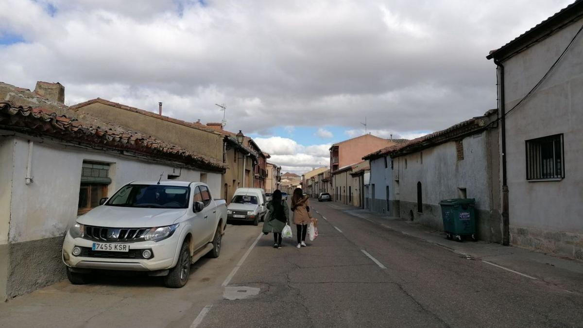 Dos vecinas pasean por la travesía de acceso al barrio toresano de Tagarabuena | M. J. C.