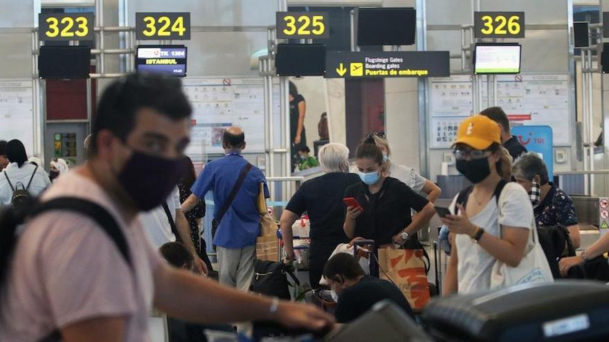 Viajeros en el aeropuerto de Málaga, vistiendo mascarillas.