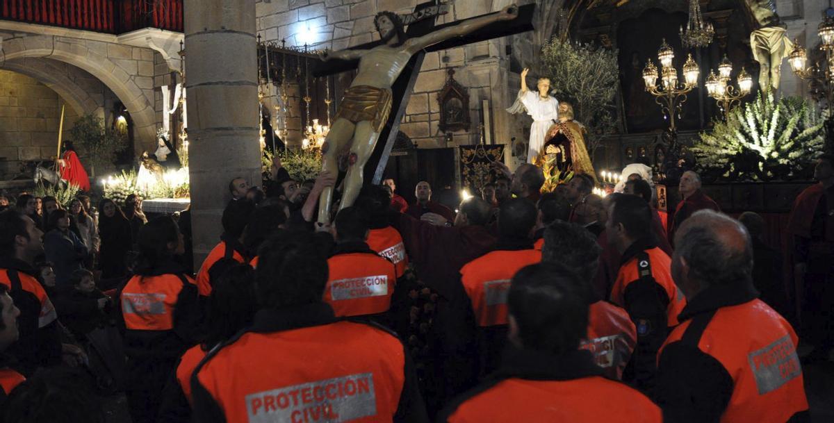 Miembros de Protección Civil de Cangas levantando la imagen  de su patrón, el «Cristo da Pila». | M.G.