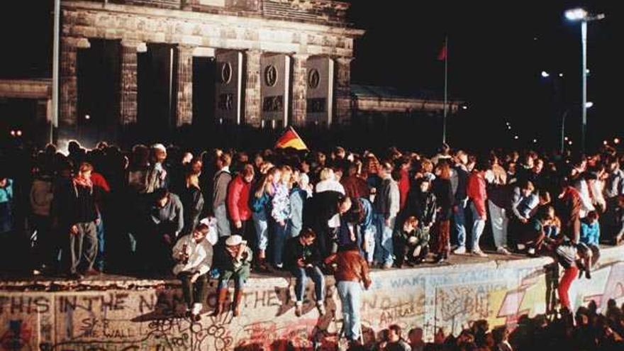 Ciudadanos de la Alemania Federal y la Alemania comunista, encima del Muro, en la Puerta de Brandemburgo en 1989.