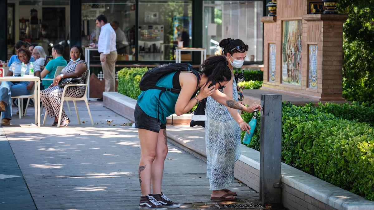 Dos mujeres se hidratan en una fuente de Badajoz por calor.