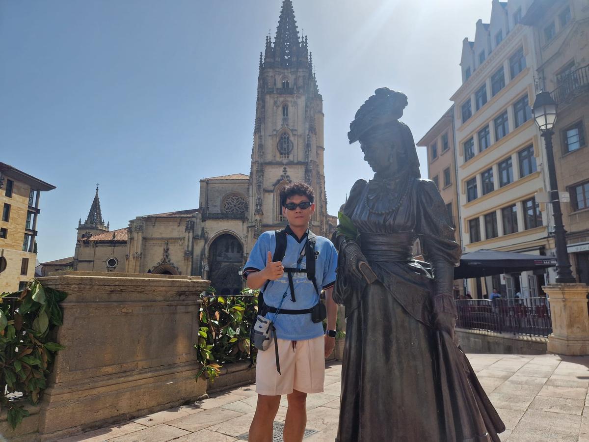 El turista chino Esteban Gao posando junto a la estatua de La Regenta.