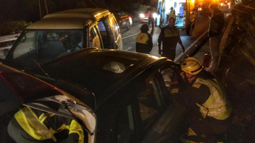 los bomberos trabajan para liberar a la mujer atrapada en el coche, ayer.