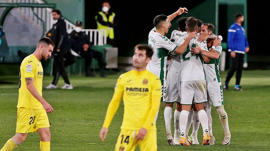 El Elche celebra el empate ante el abatimiento de los futbolistas del Villarreal. | EFE/RAMÓN