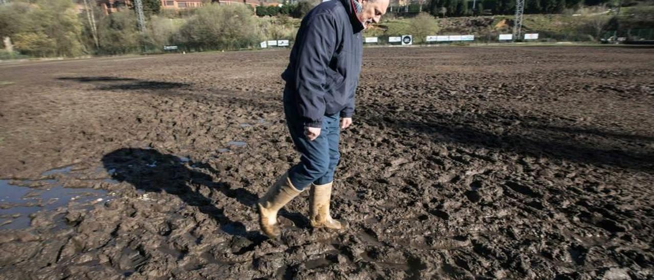 El presidente del Oviedo Rugby, Francisco Baruque, caminando entre el fango del terreno de juego.