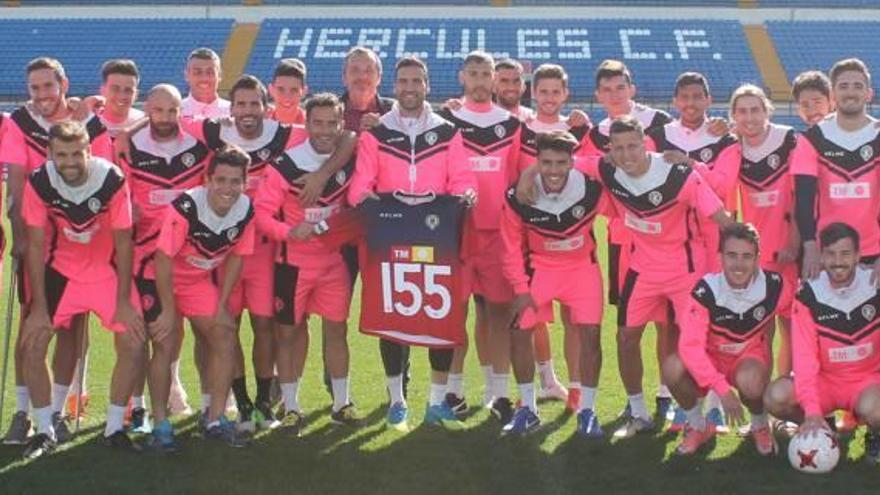 Los jugadores y técnicos del Hércules posan ayer junto a Falcón y su camiseta conmemorativa en el Rico Pérez.