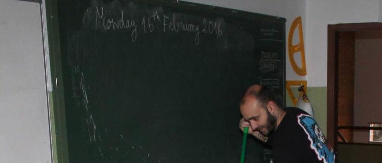 El profesor Nacho González, días atrás, recogiendo agua con una fregona en una de las aulas con goteras del colegio de Siero.