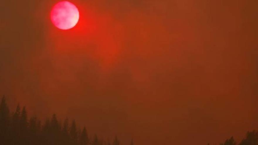 El fum de les flames tenyeix de vermell el sol i el cel a prop de la ciutat de Redding