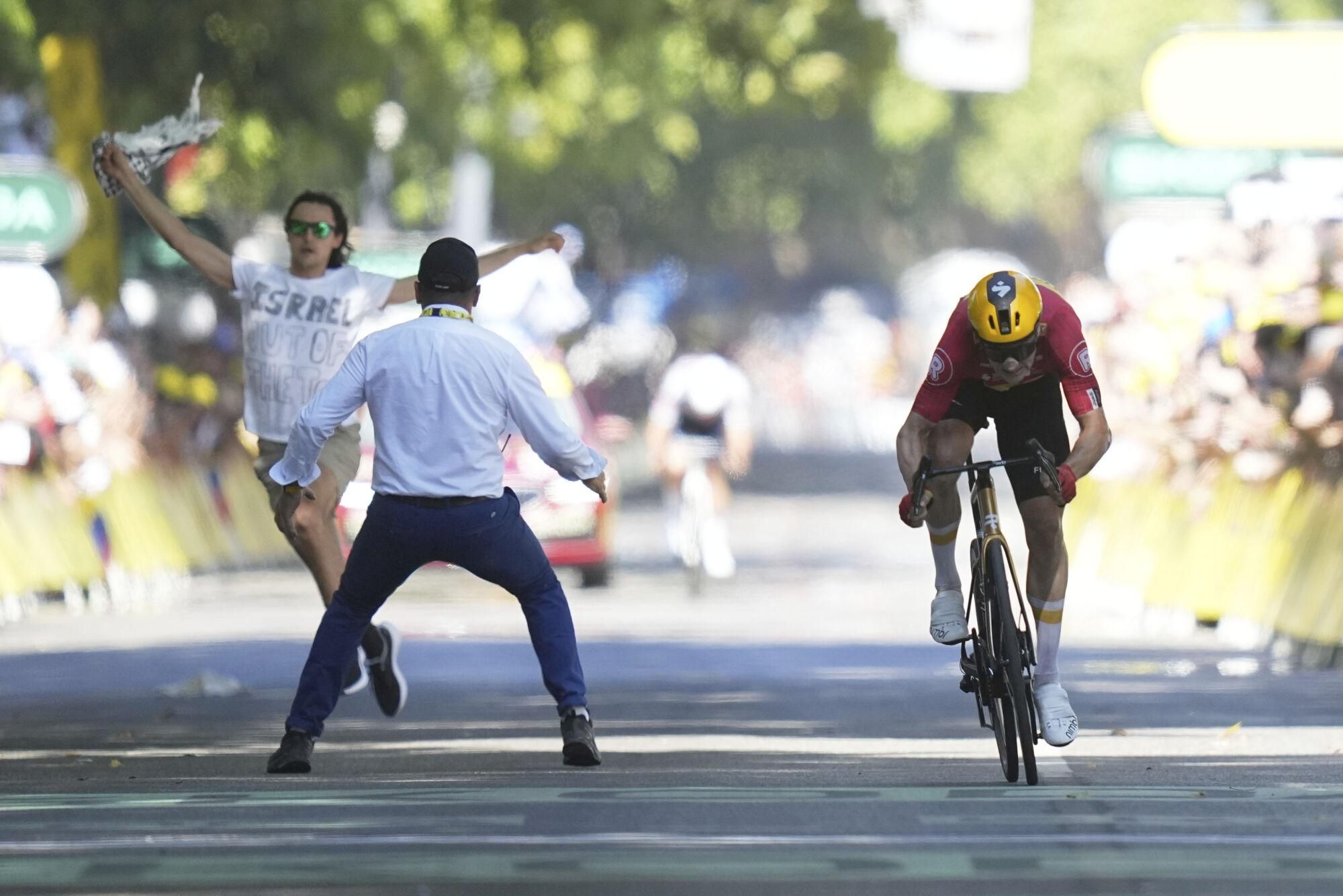 Norway's Jonas Abrahamsen sprints as a protester tries to cross the finish line during the eleventh stage of the Tour de France cycling race over 156.8 kilometers (97.4 miles) with start and finish in Toulouse, France, Wednesday, July 16, 2025. (AP Photo/Thibault Camus). EDITORIAL USE ONLY / ONLY ITALY AND SPAIN
