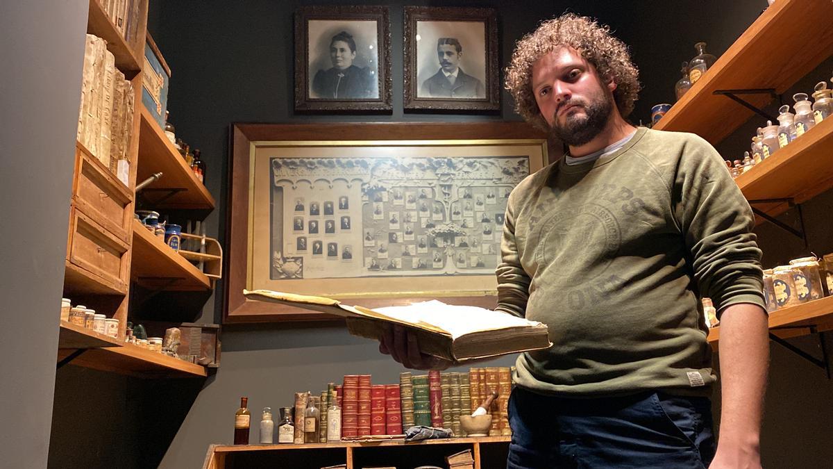 El director del Museu de Llívia, Gerard Cunill, mirant un dels volums del fons bibliogràfic de l&#039;antiga farmàcia Esteva a les instal·lacions de l&#039;equipament