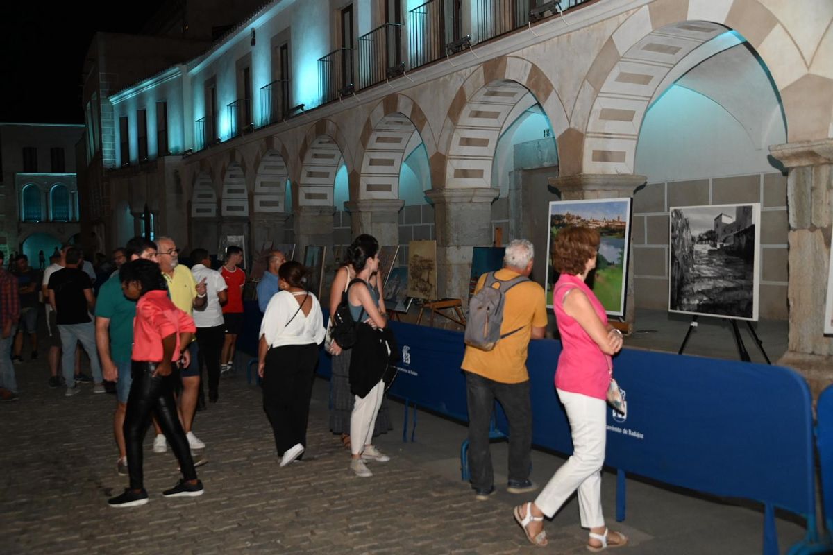 Los curiosos observan los cuadros en la plaza Alta.